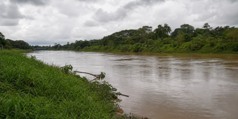 Rio Acre em Rio Branco durante período de aumento das chuvas, com margem ribeirinha e vegetação amazônica ao fundo