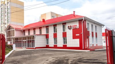 Fachada de uma clínica moderna com estrutura nas cores vermelha e branca.