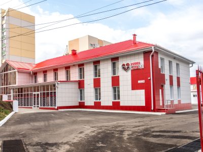 Fachada de uma clínica moderna com estrutura nas cores vermelha e branca.