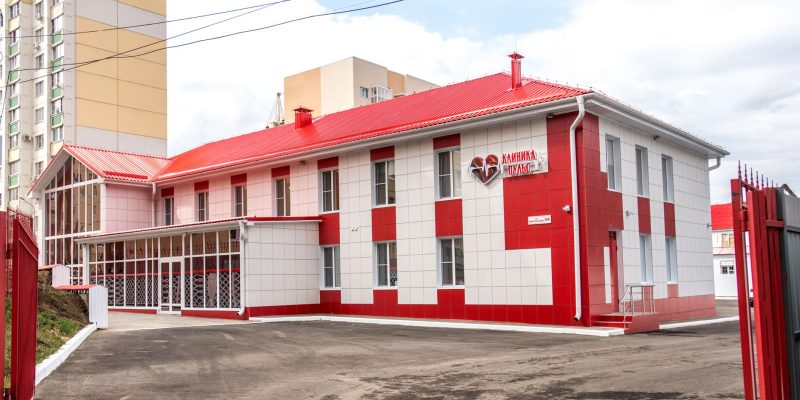 Fachada de uma clínica moderna com estrutura nas cores vermelha e branca.