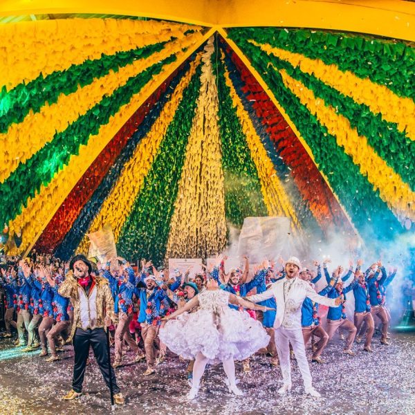 Dançarinos se apresentam em um palco durante um festival brasileiro.