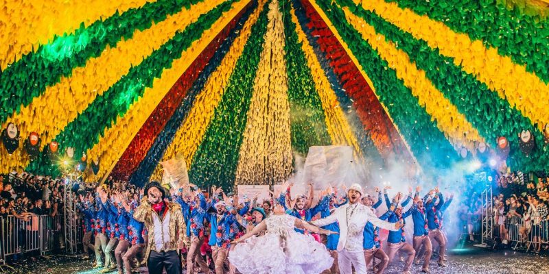 Dançarinos se apresentam em um palco durante um festival brasileiro.
