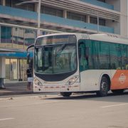 Ônibus urbano parado em um ponto enquanto passageiros embarcam.
