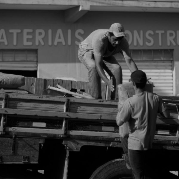 Trabalhadores colaboram durante uma atividade em uma área industrial urbana.
